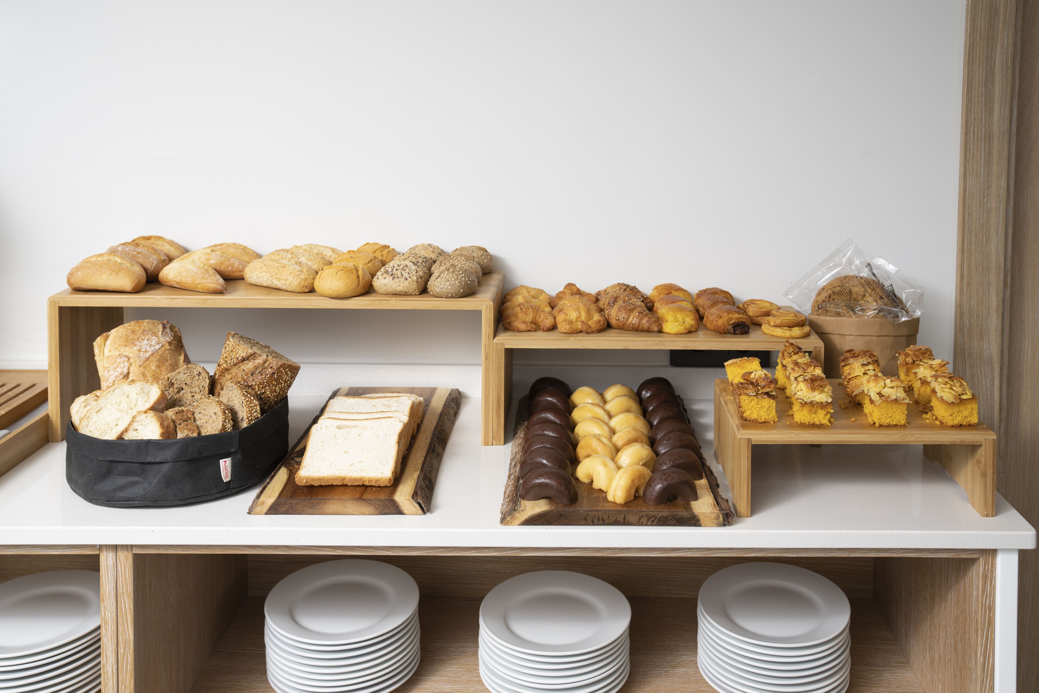 Un bufé con diversos productos de panadería y pastelería.