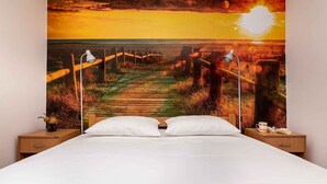 Une chambre à coucher avec un lit, deux tables de chevet et une lampe fixée au mur.
