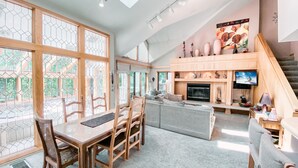 A spacious living room with a high ceiling, a fireplace, and a television. - Chateaux Dumont 2725 (Keystone)
