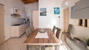 Une cuisine moderne avec des meubles en bois, une table à manger avec des chaises et un four encastré.