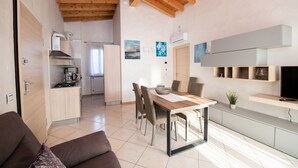 Une cuisine moderne avec un coin repas, un plafond en bois et un téléviseur placé sur une étagère intégrée.