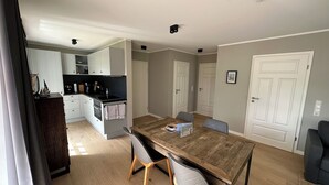Apartamento moderno com sala de jantar, cozinha e dois quartos.