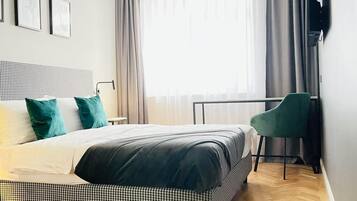 Una habitación de hotel moderna con una cama grande, un escritorio y una silla.