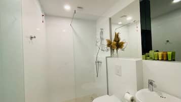 Un baño moderno con ducha envuelta en vidrio, inodoro y lavamanos.