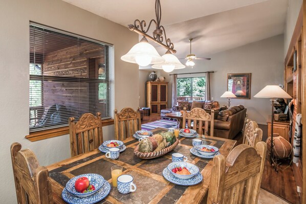 A dining area with a wooden table set for breakfast, surrounded by wooden chairs.