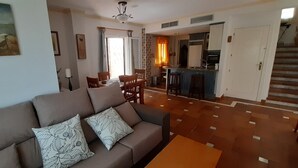 A living room with a sofa, a dining area, and a kitchen. - NUEVA Increíble casa con vistas al mar y piscina (Almuñécar)