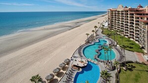 Ein Resort mit großem Pool, Strandlage und einem mehrstöckigen Gebäude.