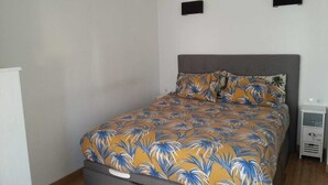 Ein Schlafzimmer mit einem Bett, einem Nachttisch und einem Wandregal.