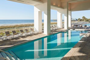 A pool area with lounge chairs and a view of the beach. - Myrtle Beach SC | Partial Ocean View Seaside Getaway | Pool + Beach (Myrtle Beach)