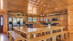 Una cocina amplia con armarios de madera, electrodomésticos de acero inoxidable y una isla central con bancos.