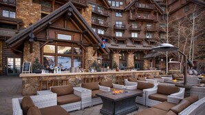 A lodge with outdoor seating, stone walls, and a bar area. - Ritz-Carlton Bachelor Gulch King Suite. Unmatched Luxury (Edwards)