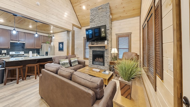 A modern kitchen with wooden cabinets, a central island, and a built-in stove. - Twisted Pines by Smoky Cove Resort (Sevierville)