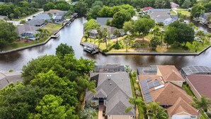 A residential area with houses, a canal, and greenery. - Splashing Dolphins by Distinctive Beach Rentals (Palm Coast)