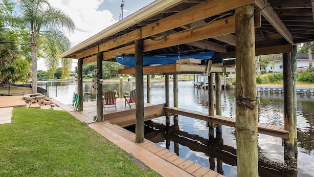 A wooden dock extending over a body of water, supported by wooden pillars. - Splashing Dolphins by Distinctive Beach Rentals (Palm Coast)
