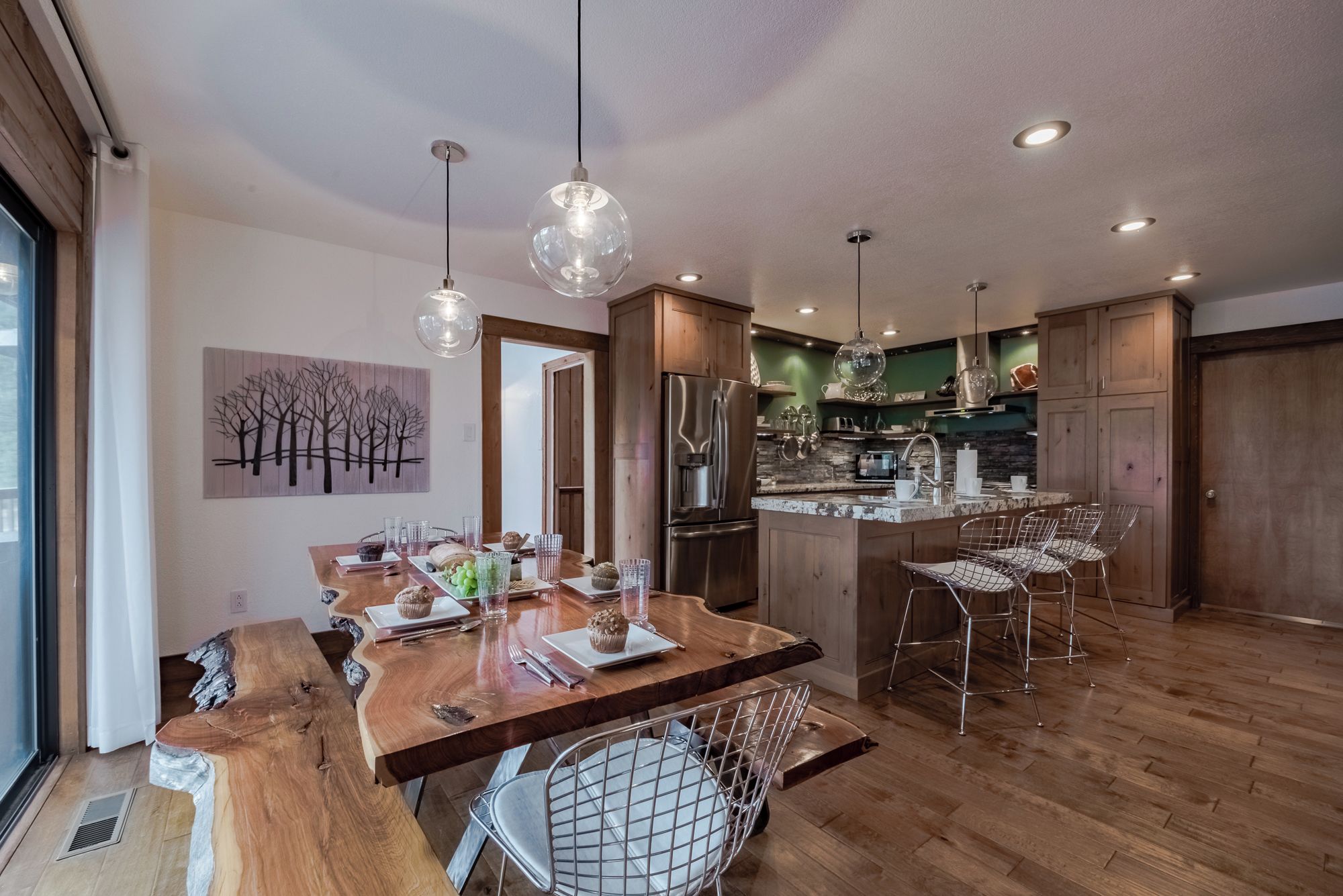 A modern kitchen with wooden cabinets, stainless steel appliances, and a central island with bar stools.
