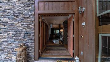 A stone wall, wooden door, and a welcome mat at the entrance of a building.