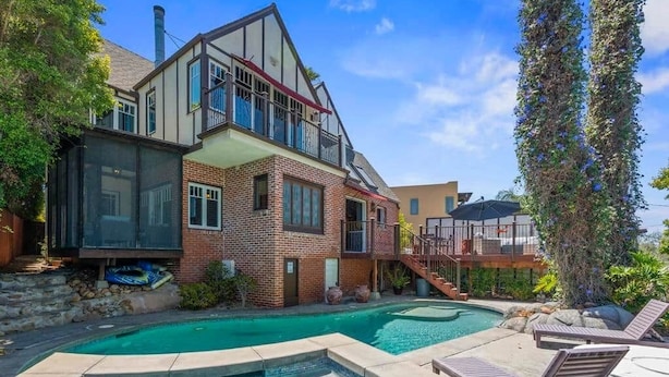 A two-story house with a swimming pool and outdoor seating. - The Kensington Canyon Estate | Celebrity Vacation Homes (San Diego)