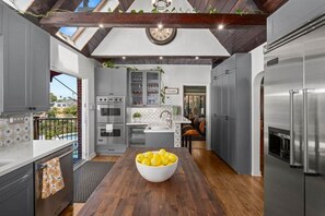 Una cocina moderna con una isla central, electrodomésticos integrados y vistas al exterior.