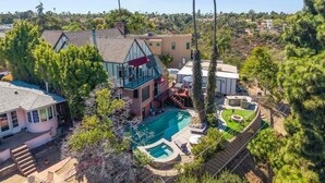 A residential property with a swimming pool, multiple buildings, and surrounding greenery. - The Kensington Canyon Estate | Celebrity Vacation Homes (San Diego)