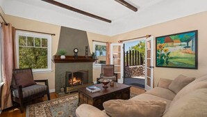 Una sala de estar con chimenea, un sofá, una mesa de centro y un cuadro en la pared.