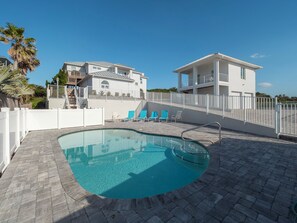 A swimming pool with a curved edge, surrounded by a paved deck. - Jean's Dream (St. Augustine)