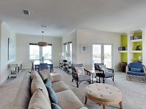 A spacious living room with a sectional sofa, a dining area, and a bright green accent wall. - Jean's Dream (St. Augustine)