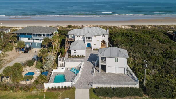 Una casa grande con piscina y vista al mar.