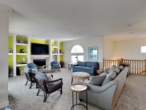 A living room with a fireplace, a television, and a bookshelf. - Jean's Dream (St. Augustine)