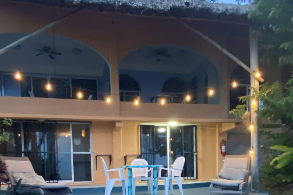 Ein Poolbereich mit Liegestühlen und einem Tisch, umgeben von einem gepflegten Rasen.