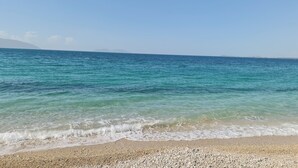 A beach with clear turquoise water, pebbly shore, and distant mountains. - Holiday One Bedroom Sea View Apartment Vlore (Vlore)