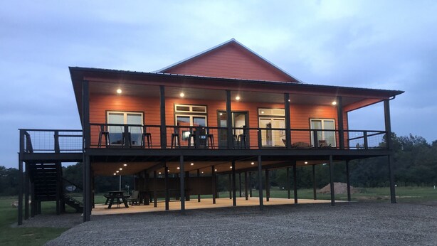 A two-story house with a red roof and a balcony. - Time For Livin…just a few steps from the Caddo River (Glenwood)