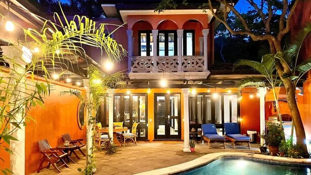 A poolside area with a pool, lounge chairs, and a building with a balcony. - Villa Cerca Del Mar #6- 3BR House with Pool (Langosta)
