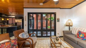 A modern living room with a sofa, chairs, a coffee table, and a kitchen in the background. - Villa Cerca Del Mar #6- 3BR House with Pool (Langosta)