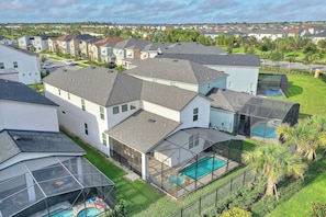 Un quartier résidentiel avec des maisons modernes, une piscine et un patio couvert.