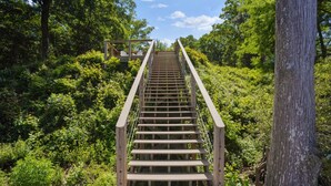 A wooden staircase leading up a hill, surrounded by dense greenery and trees. - Chickahominy Riverside Guest Home 30 Minutes to Williamsburg! (Charles City)