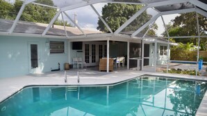 A covered swimming pool with a patio area, a covered seating area, and a view of the backyard. - Arlington Park Area! 3BR/2BA Sarasota Home – Heated Large Pool (Sarasota)