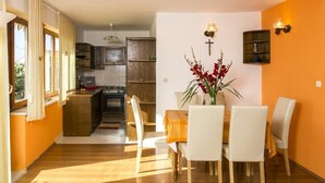 Una cuina moderna amb armaris de fusta i una zona de menjador amb taula i cadires.