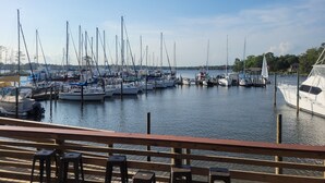 A marina with multiple boats docked, wooden deck seating, and a clear view of the water. - Lovely Bluewater Bay 1 Bedroom Condo near Bluewater Bay Marina and Destin Island (Niceville)