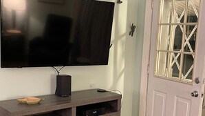 Ein Holz-Entertainment-Center mit Flachbildfernseher, Lautsprecher und Spielkonsole.