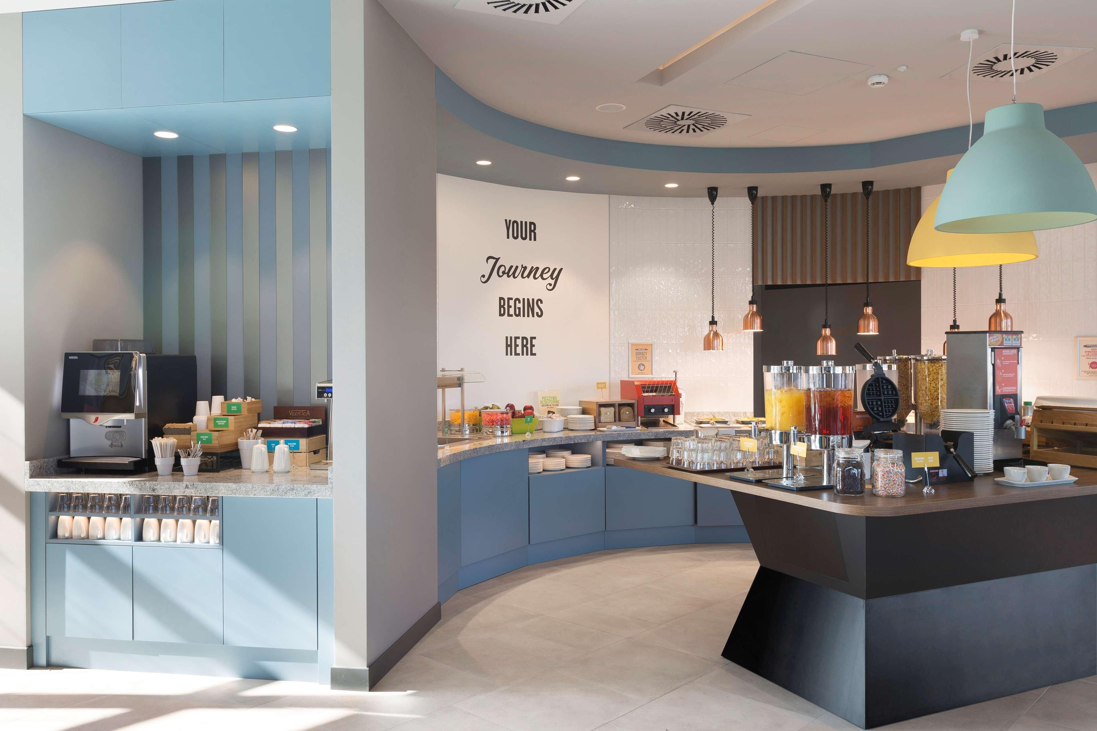 A modern breakfast bar with a counter, seating area, and a wall with motivational text.