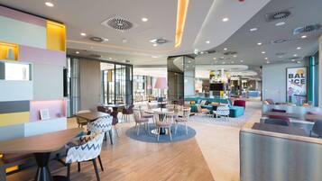 A modern interior with a central dining area, seating arrangements, and a visible bar area.