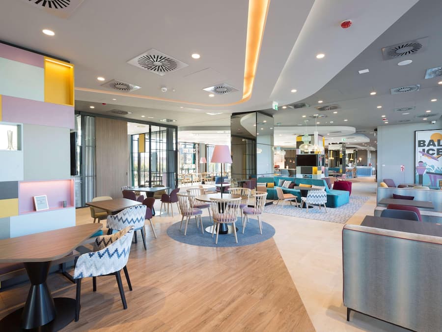 A modern interior with a central dining area, seating arrangements, and a visible bar area.