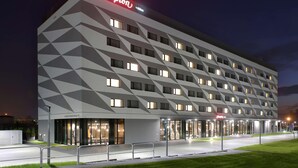 Een modern hotel met een geometrisch gevelontwerp, meerdere verdiepingen en een opvallend 'Hampton'-bord.