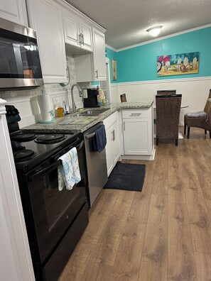 Enjoy cooking in this well-equipped kitchen with a microwave, stove, and oven, and dine in the adjacent seating area.