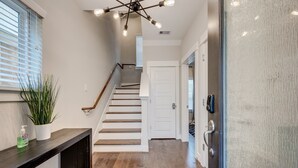 Una escalera de madera con paredes blancas que conduce a una puerta.