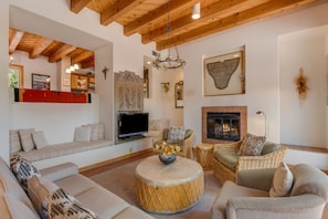A cozy living room with a fireplace, a television, and comfortable seating. - Acoma - Majestic Views, Near the Santa Fe Opera and Four Seasons in Tesuque (Santa Fe)