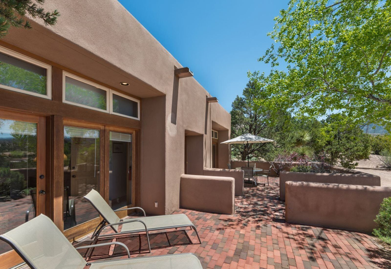 A patio area with outdoor seating and a view of a building with large windows and a door.