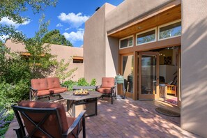 Un patio al aire libre con un brasero, dos sofás y una mesa.