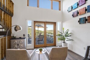 A spacious living area with a balcony, a dining table, and a sofa.