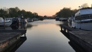 A calm waterway with boats docked on both sides, connected by a narrow passage. - Discover the diverse province of North Holland (Nieuwe Niedorp)